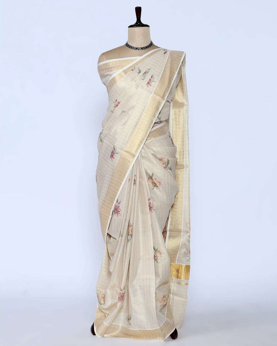 A cream-colored kerala saree with delicate floral prints and a gold border - full view