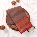 Folded Kanchi Cotton Saree Showcasing Detailed Gold Zari Motifs And Magenta Border Overhead Display View
