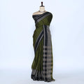 An dark green saree with black and silver patterned borders