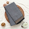 Narayanpet Cotton Saree with Paisley Zari Woven Border Grey Folded Top View on Wicker Basket