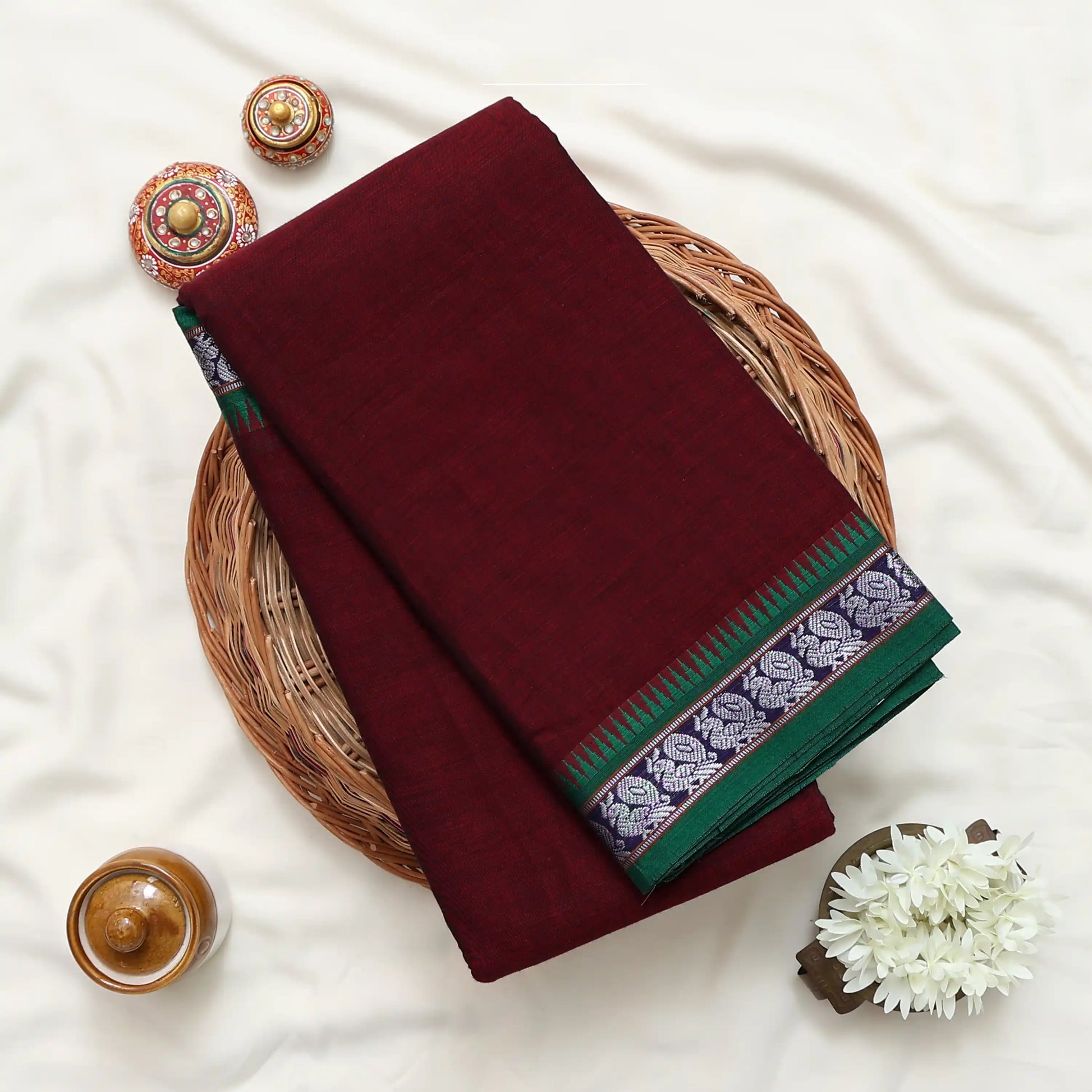 Narayanpet Cotton saree with deep purple body and silver zari woven border, folded top view