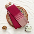 Deep magenta and beige striped saree detail showcasing woven texture and elegant striped pattern close up