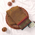 Kanchi Cotton saree with green toned weave green motifs and green pink zari border folded top view

