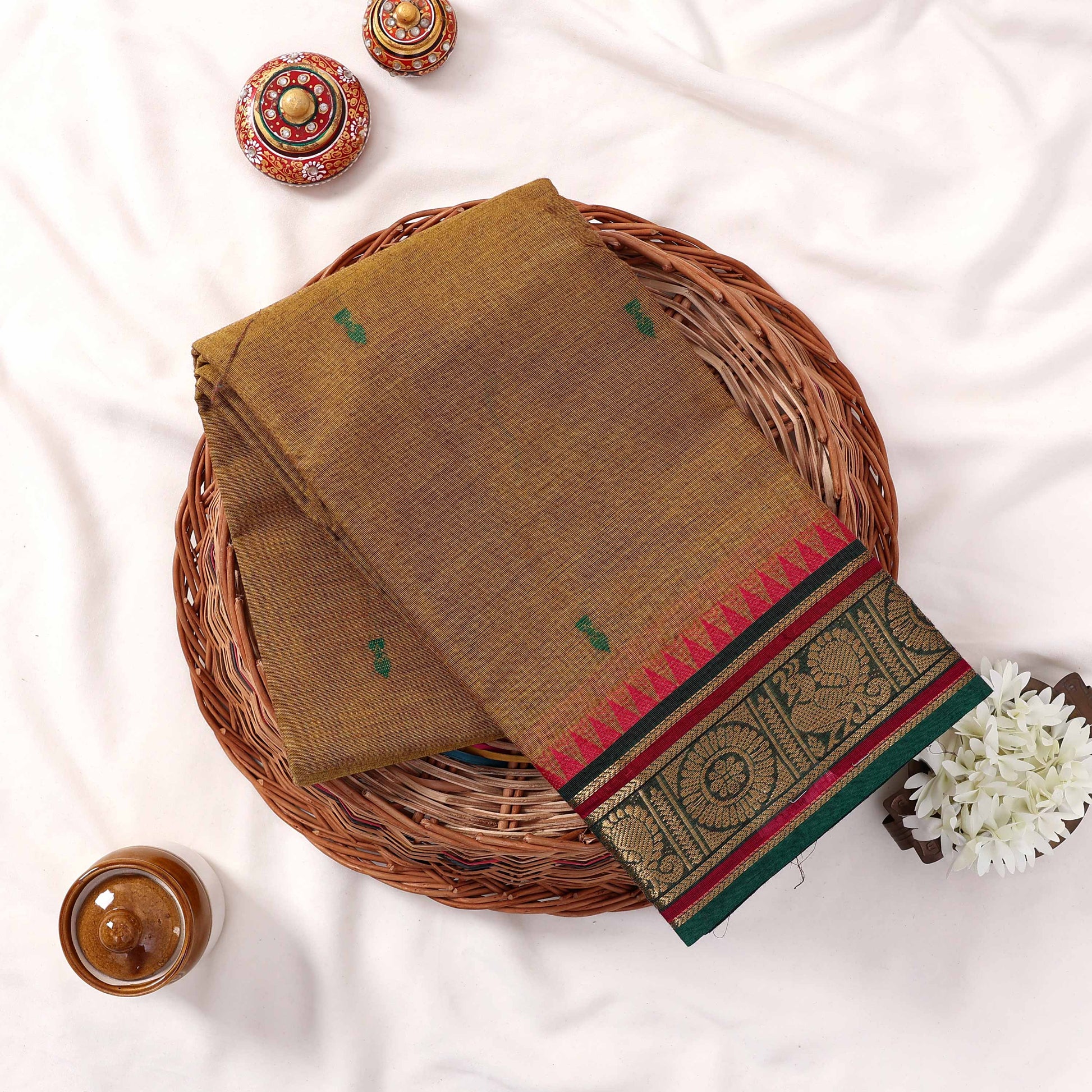 Kanchi Cotton saree with green toned weave green motifs and green pink zari border folded top view
