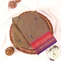 Kanchi Cotton Saree In Olive Green With Contrasting Pink Purple Border And Blue Motifs Flat Lay View
