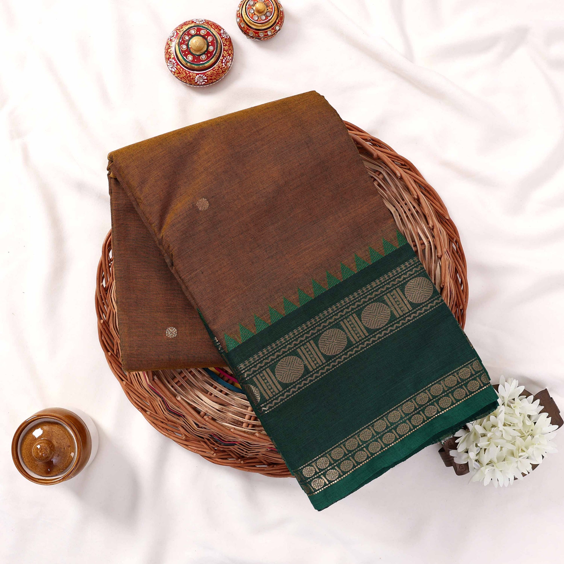 Kanchi Cotton Saree With Olive Green Body Dark Green Zari Border And Temple Design Folded Basket Top View
