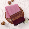 Kanchi Cotton Saree With Floral Zari Border In Pink And Maroon Folded Flat Lay View With Decorative Accents
