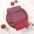 Kanchi Cotton Saree With Zari Border In Deep Purple And Maroon Folded On A Wicker Basket Top View Display
