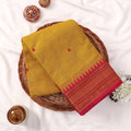 Kanchi Cotton Saree With Yellow Weave Pink Zari Border And Butta Motifs Top View Folded Display On Wicker Tray
