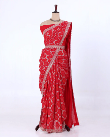 A red saree with intricate silver floral embroidery and a silver border