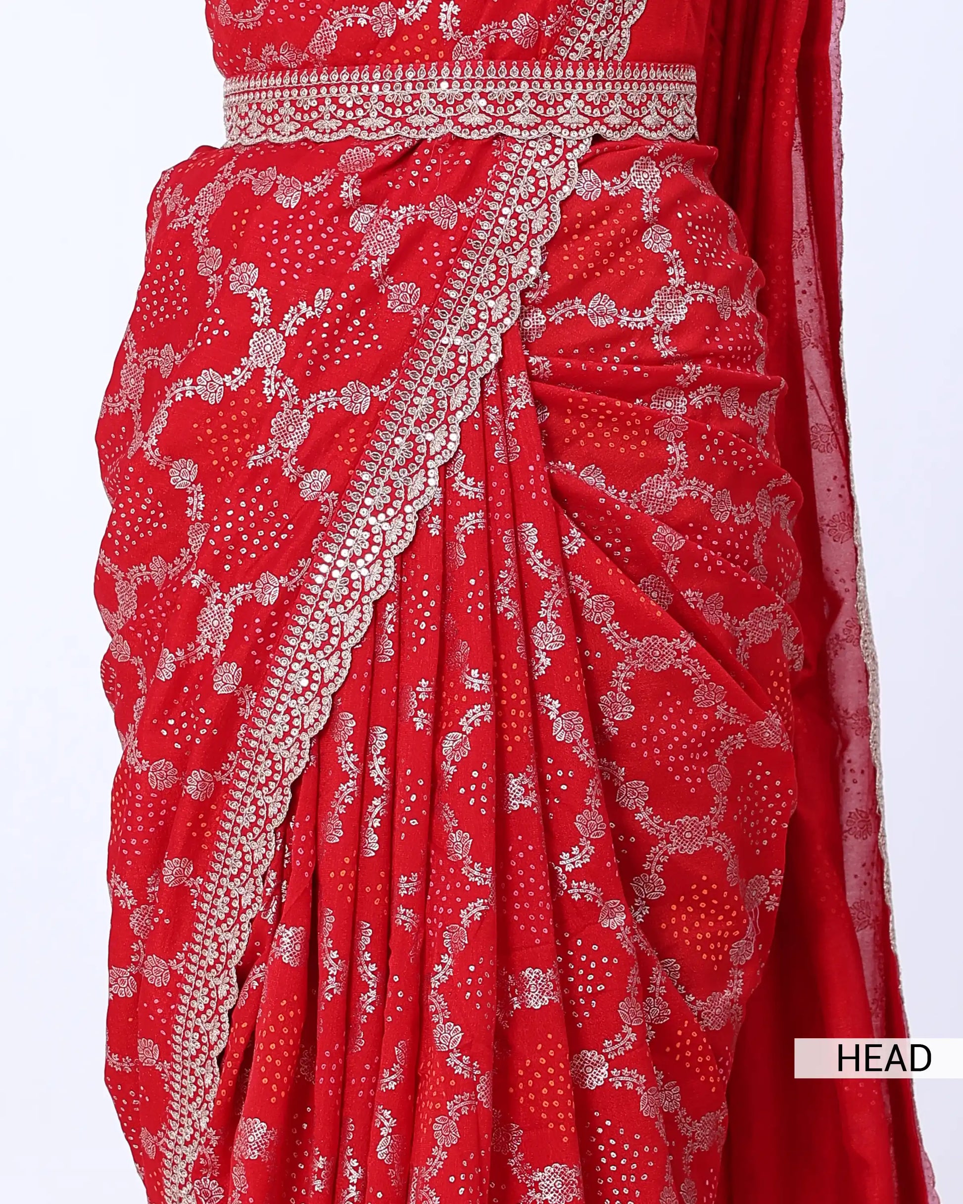 A close-up of a red saree with intricate silver floral prints and a silver border