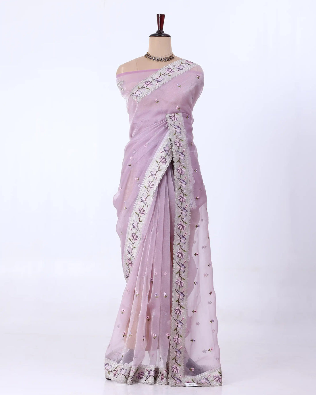 A light pink/lavender saree with silver floral embroidery and mirror work