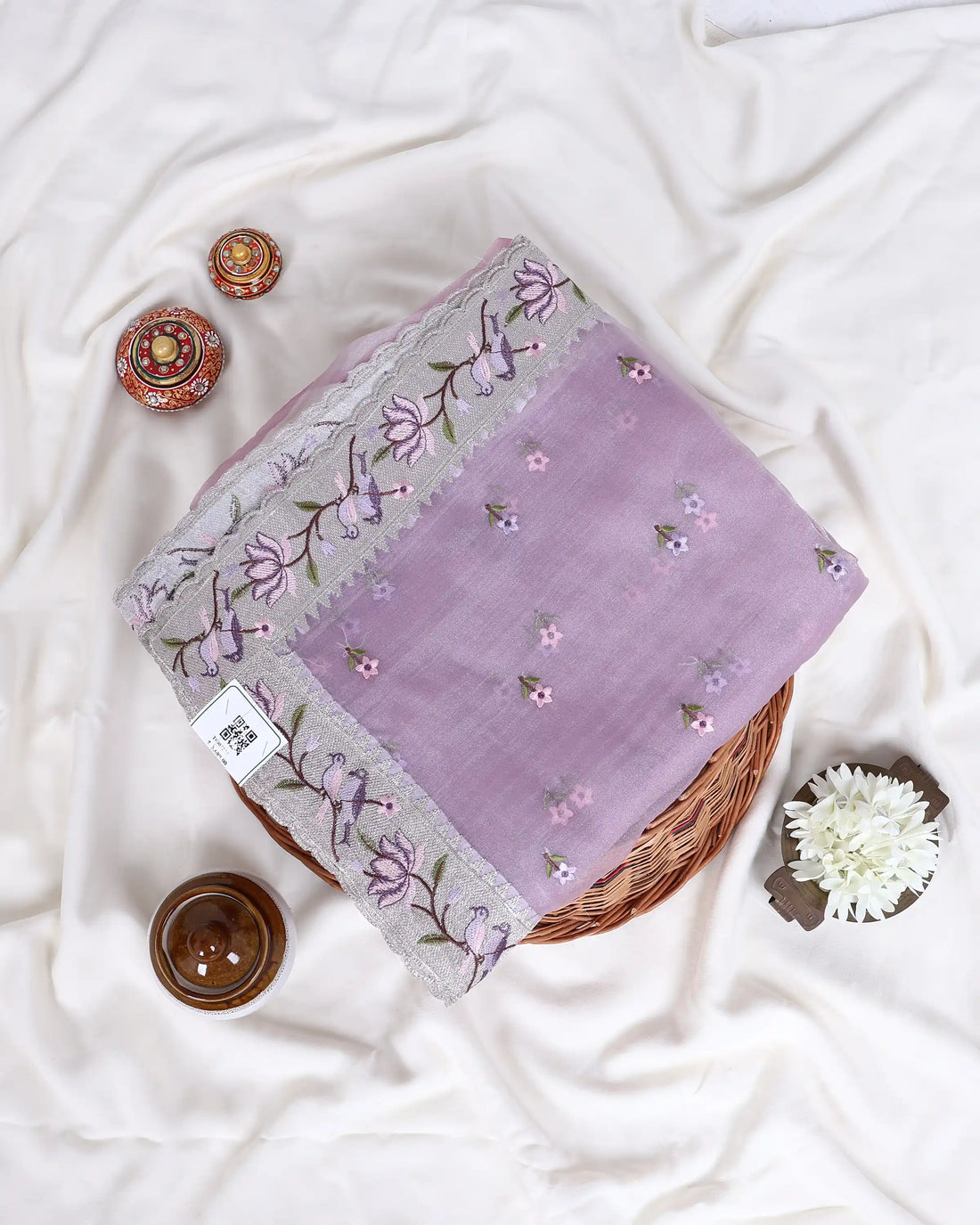 A light pink/lavender saree with silver floral embroidery and mirror work