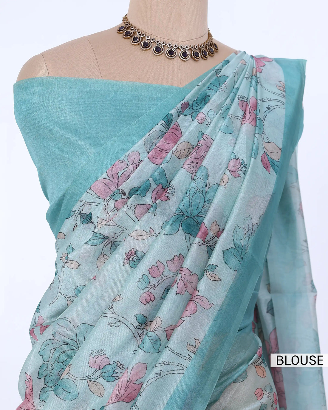 A light blue-green saree with a pink and green floral print