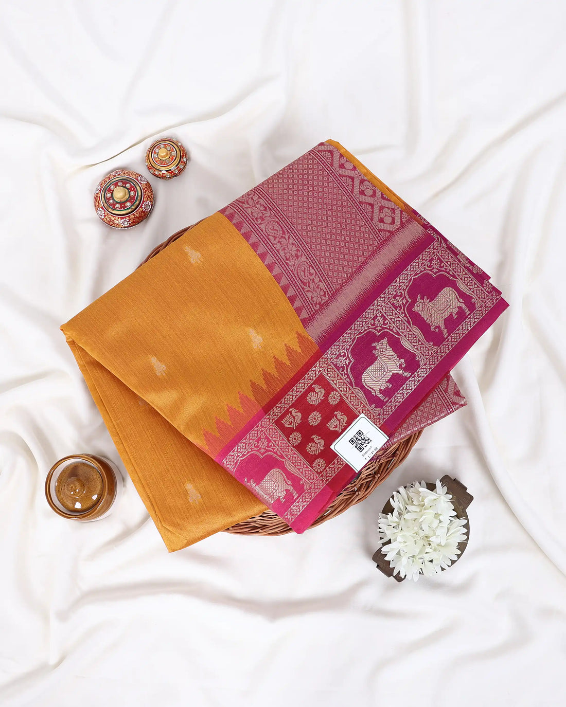 A yellow raw silk saree with a pink and magenta border