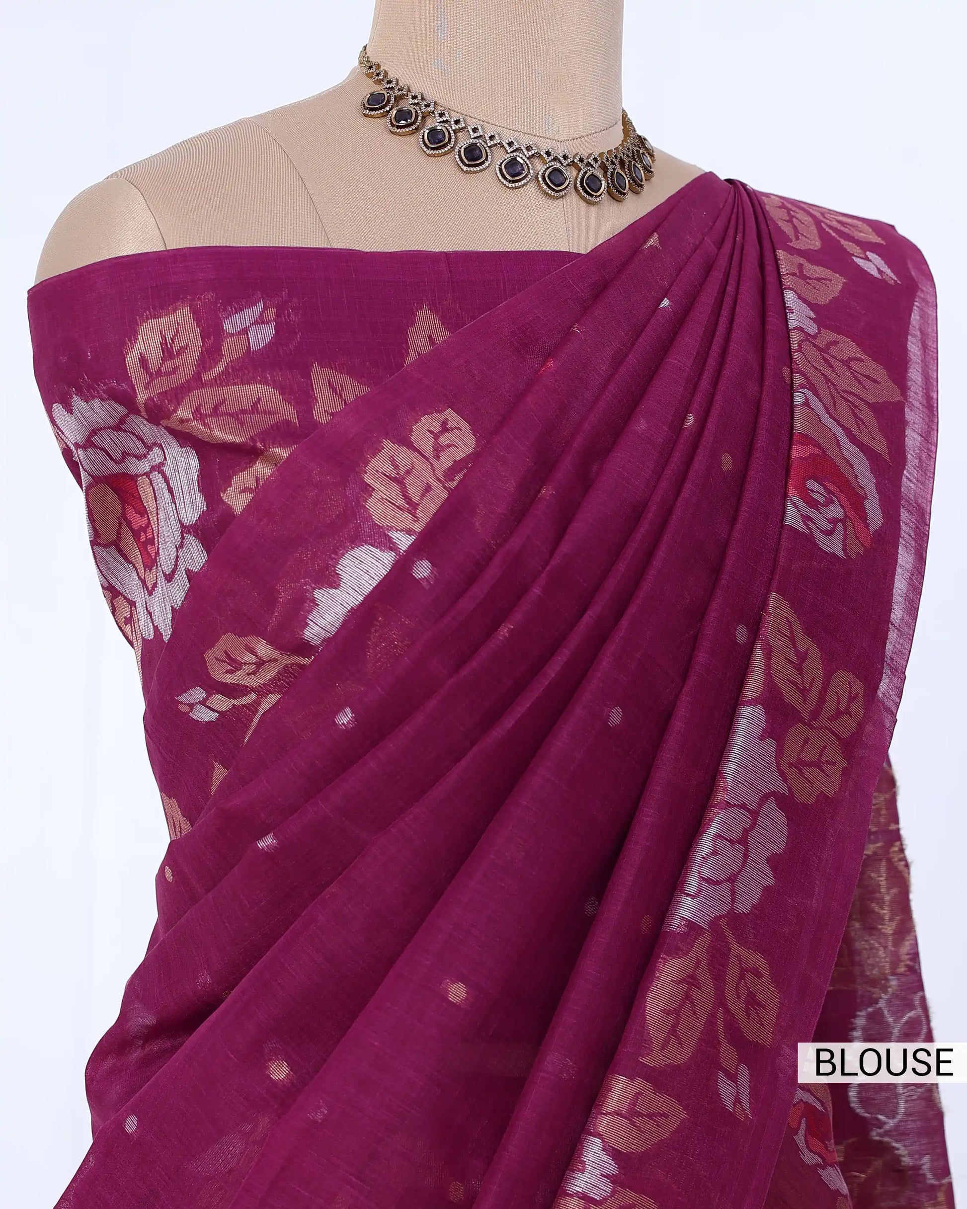 A magenta purple saree blouse with beige and white floral patterns