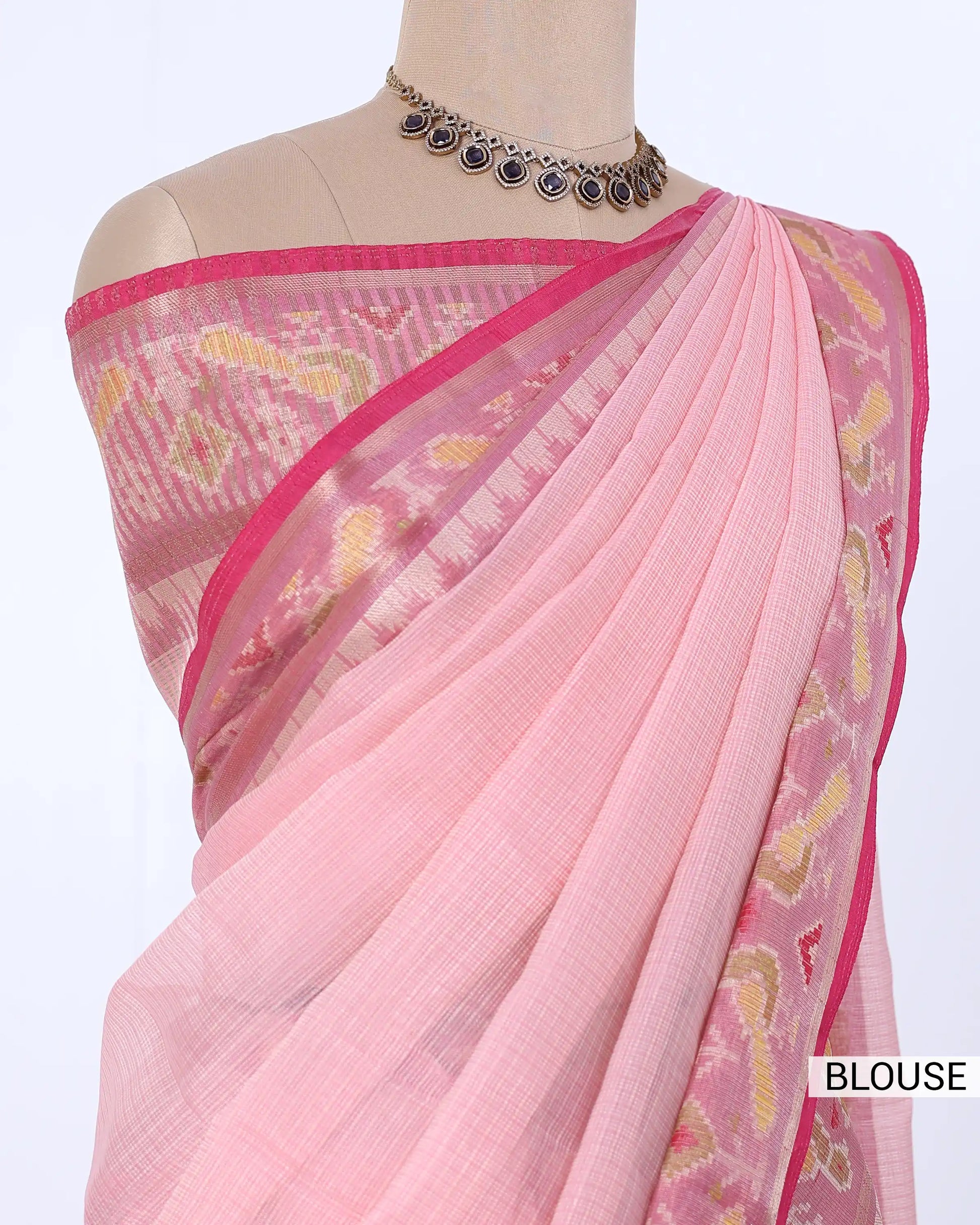 A light pink saree blouse with a pink border and yellow paisley motifs, blouse view