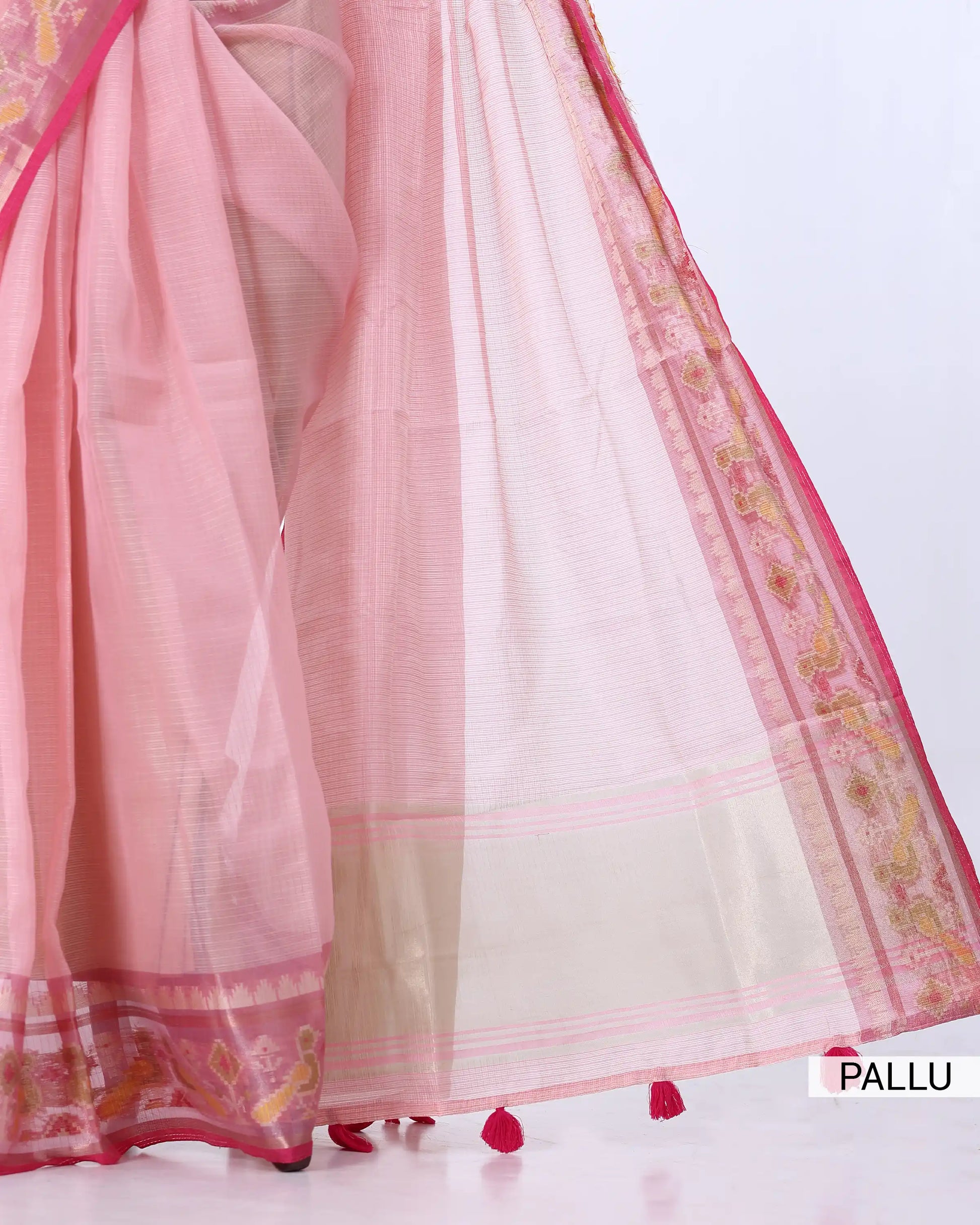 A light pink saree with a wide cream-colored pallu and ornate pink and gold border detailing,