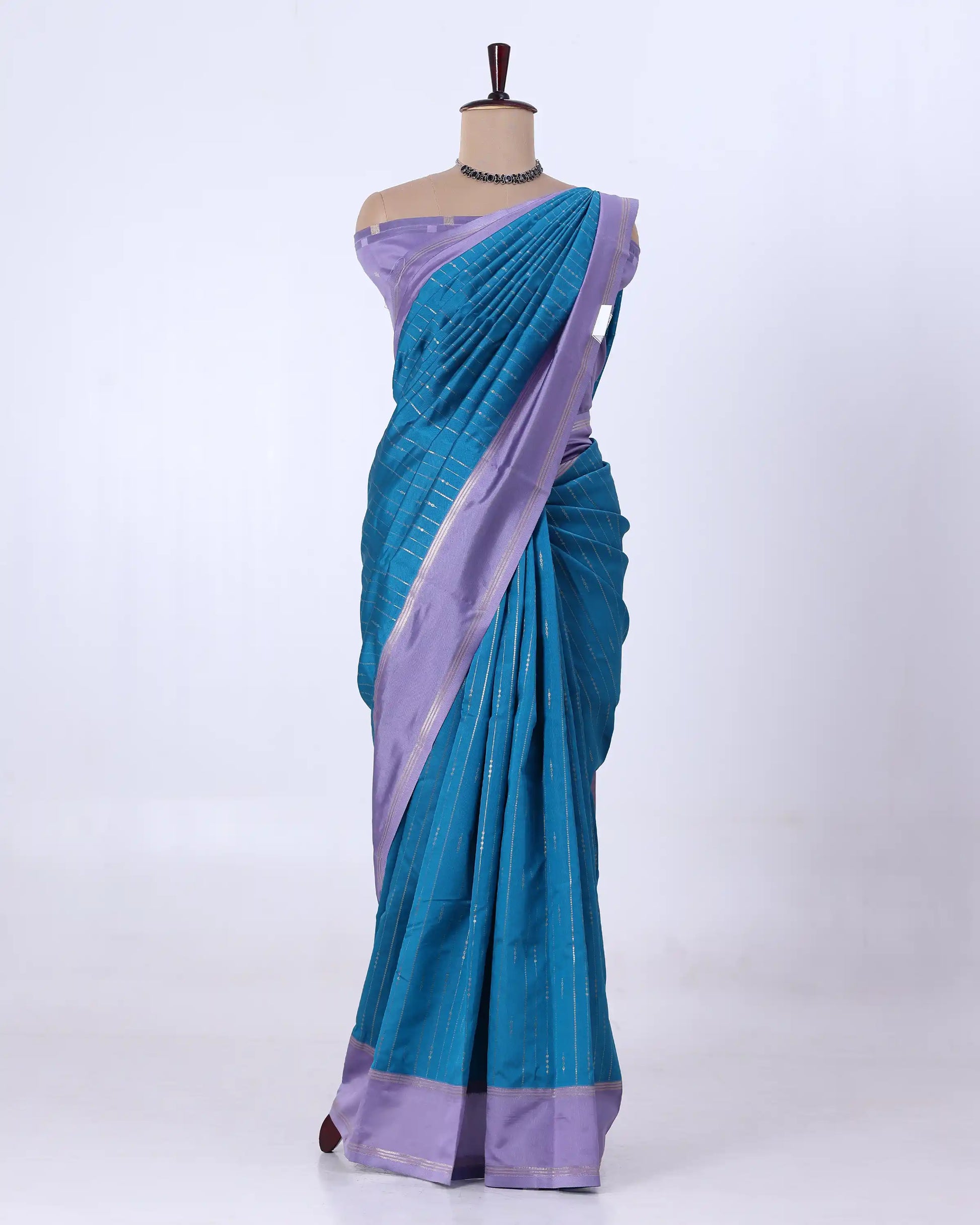 A teal blue and lavender purple silk saree with matching blouse