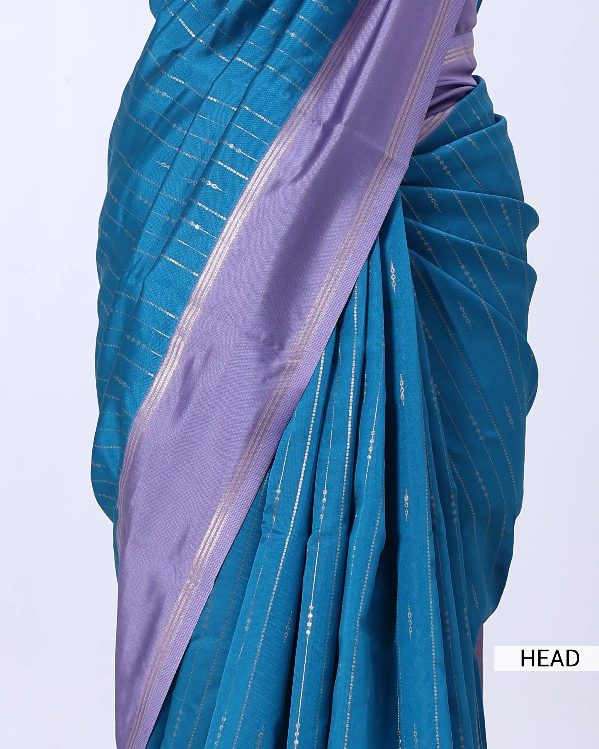 A close-up of a blue and lavender purple saree with fine metallic gold stripes