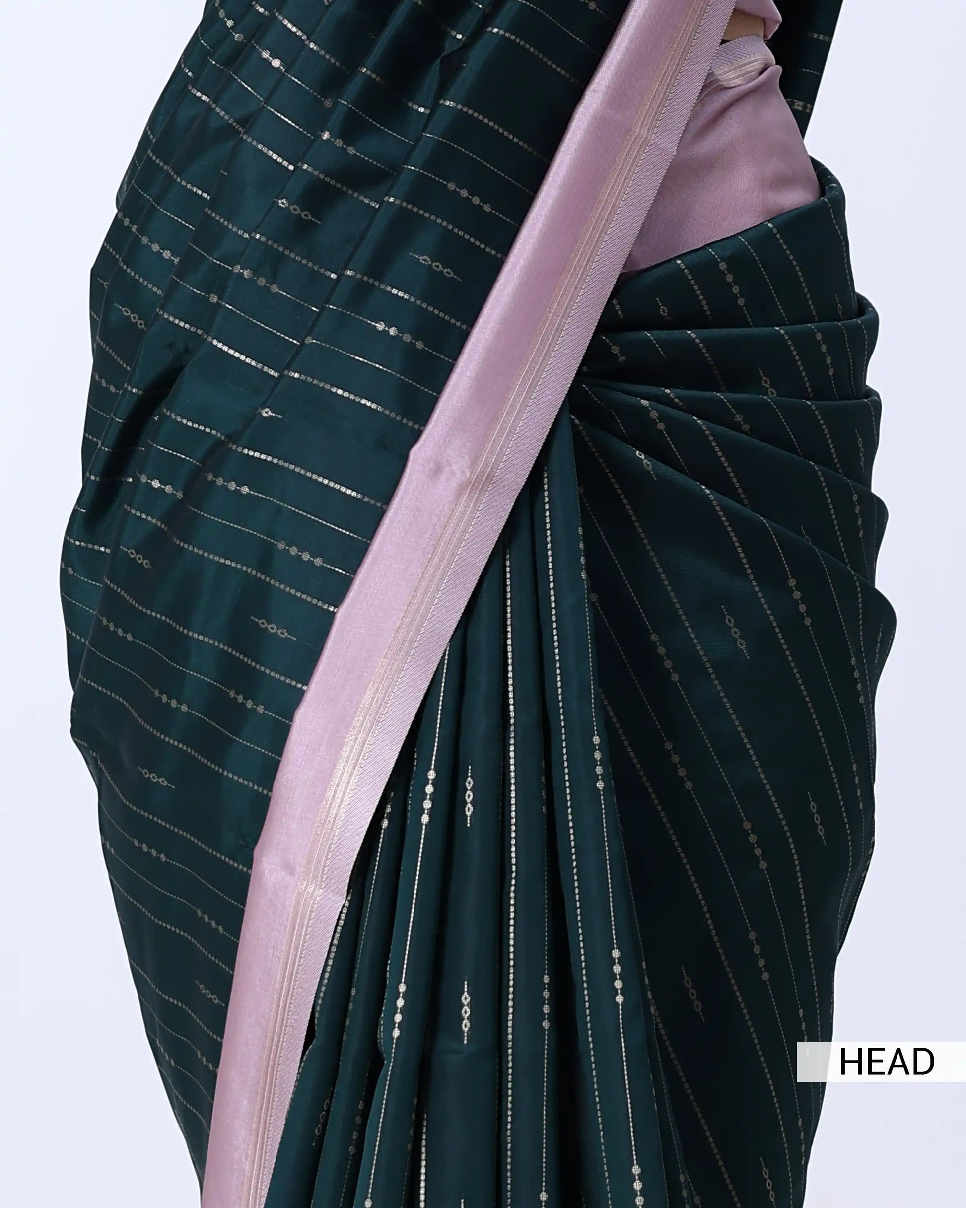 A close-up of a dark teal-green saree with thin vertical metallic gold stripes and a contrasting light pink border
