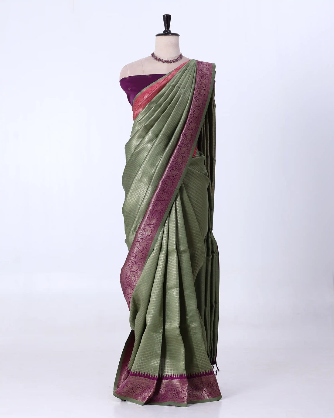 A gray silk saree with a deep purple border and a matching purple blouse 