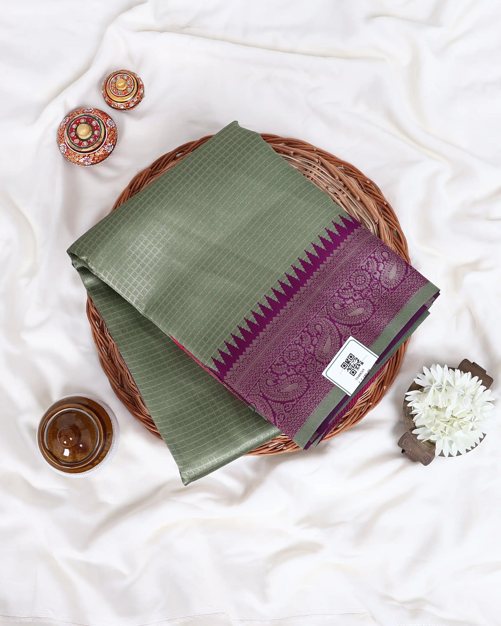 An olive green and purple silk saree elegantly folded 