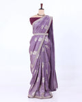 A lavender purple saree with silver floral patterns and a silver border, paired with a deep purple blouse