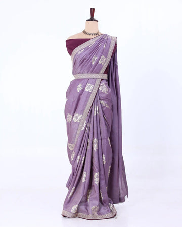 A lavender purple saree with silver floral patterns and a silver border, paired with a deep purple blouse