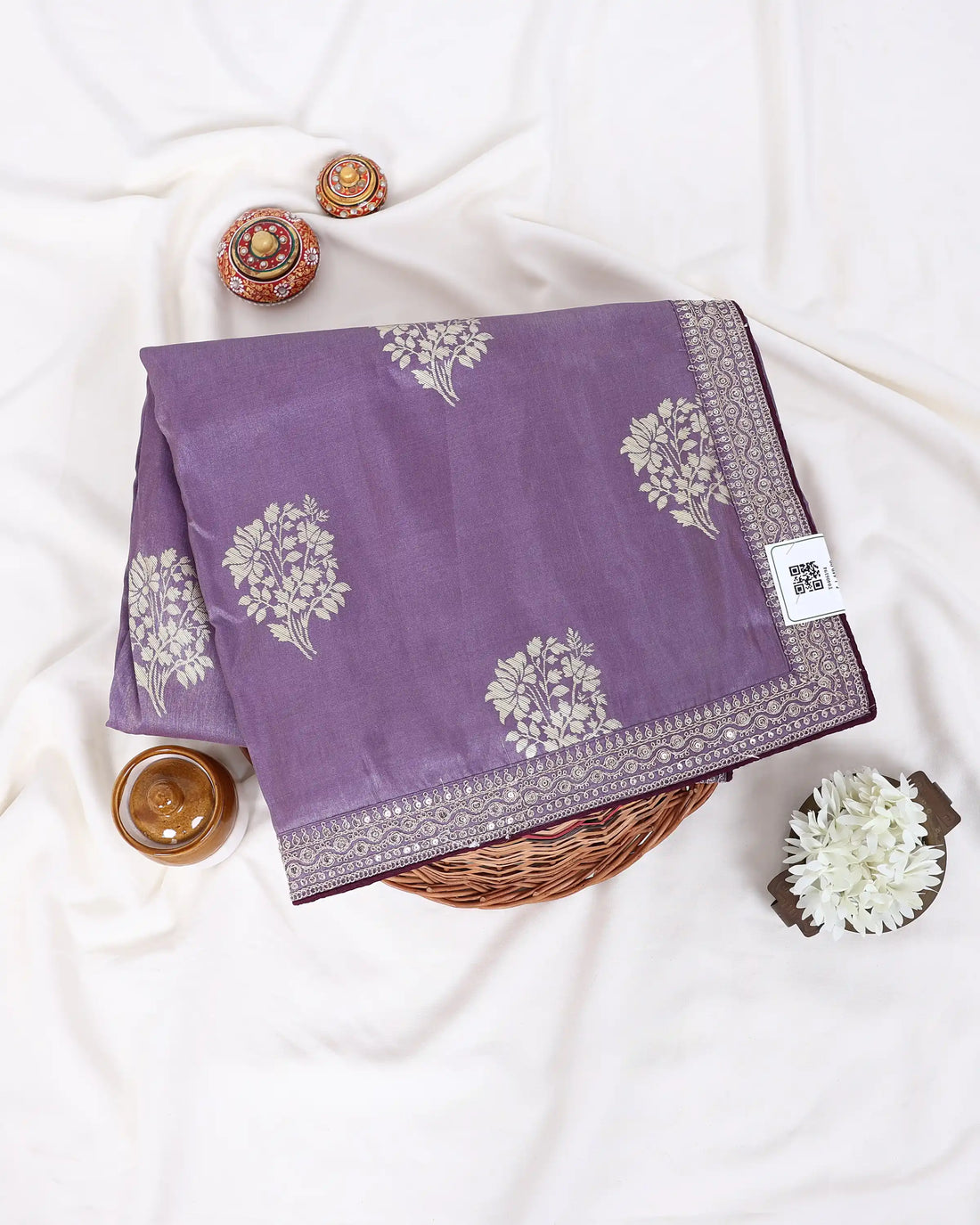 A lavender purple saree with silver floral patterns and a silver border, paired with a deep purple blouse
