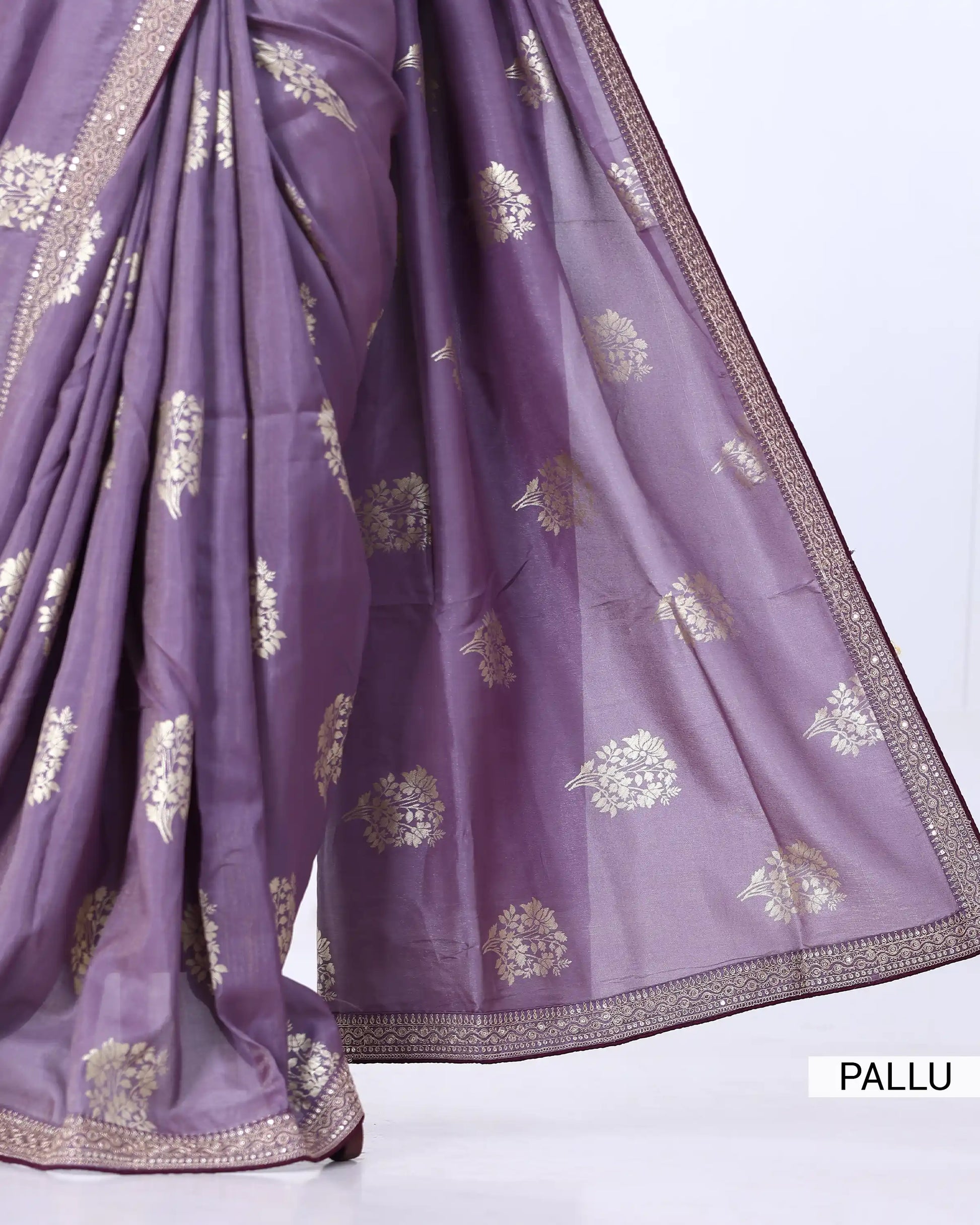 A draped purple saree with metallic gold floral motifs and a decorative gold border