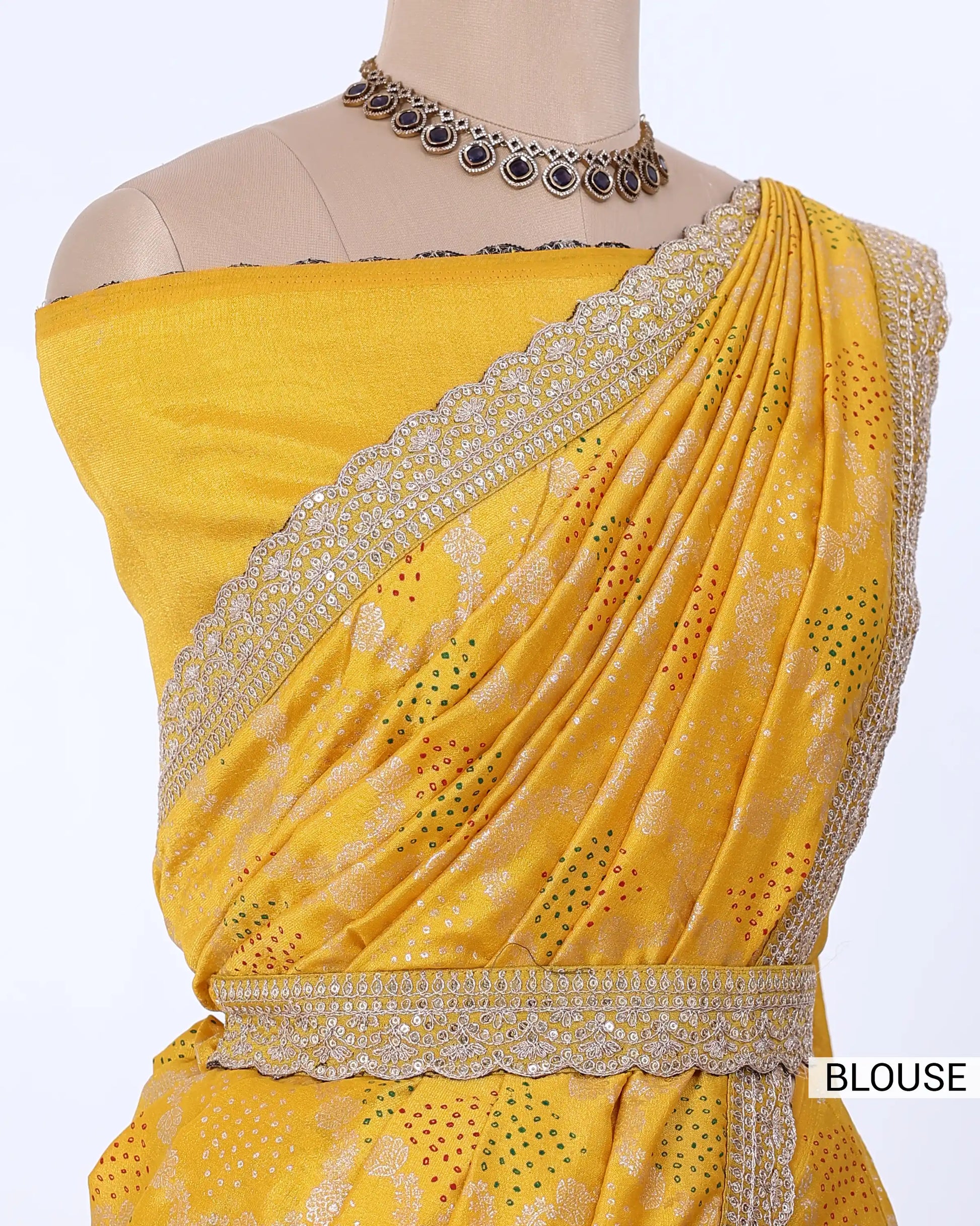 A yellow off-the-shoulder blouse with intricate silver embroidery and a matching draped sari