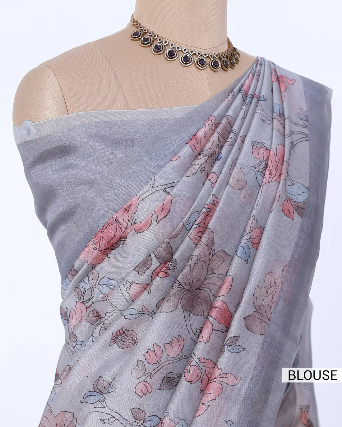 A light gray saree with a pink and green floral print