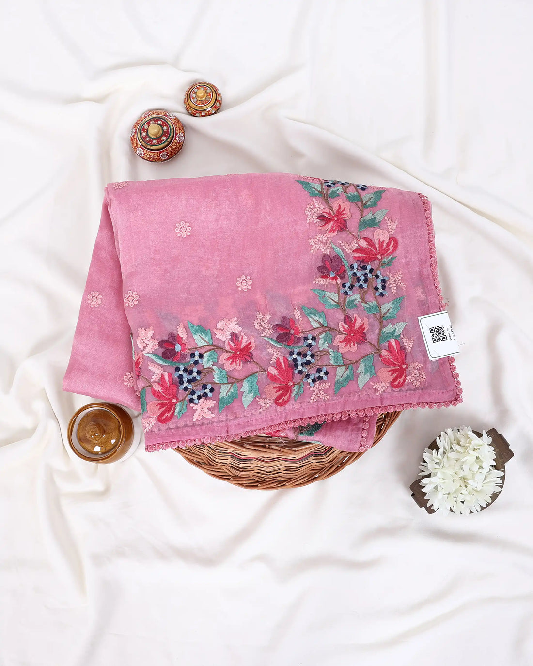 A pink saree with colorful floral embroidery on the border and pallu