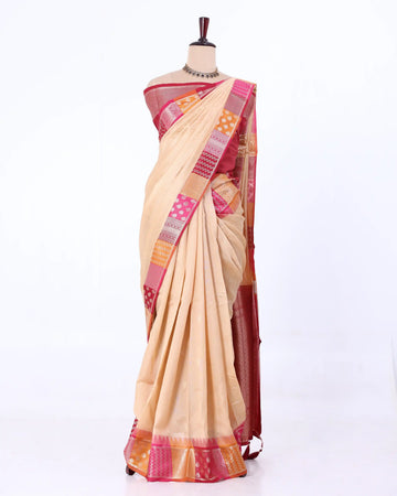 A beige raw silk saree with a pink and orange patterned border
