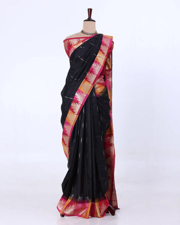 A black cotton saree with a vibrant pink, orange, and yellow patterned border