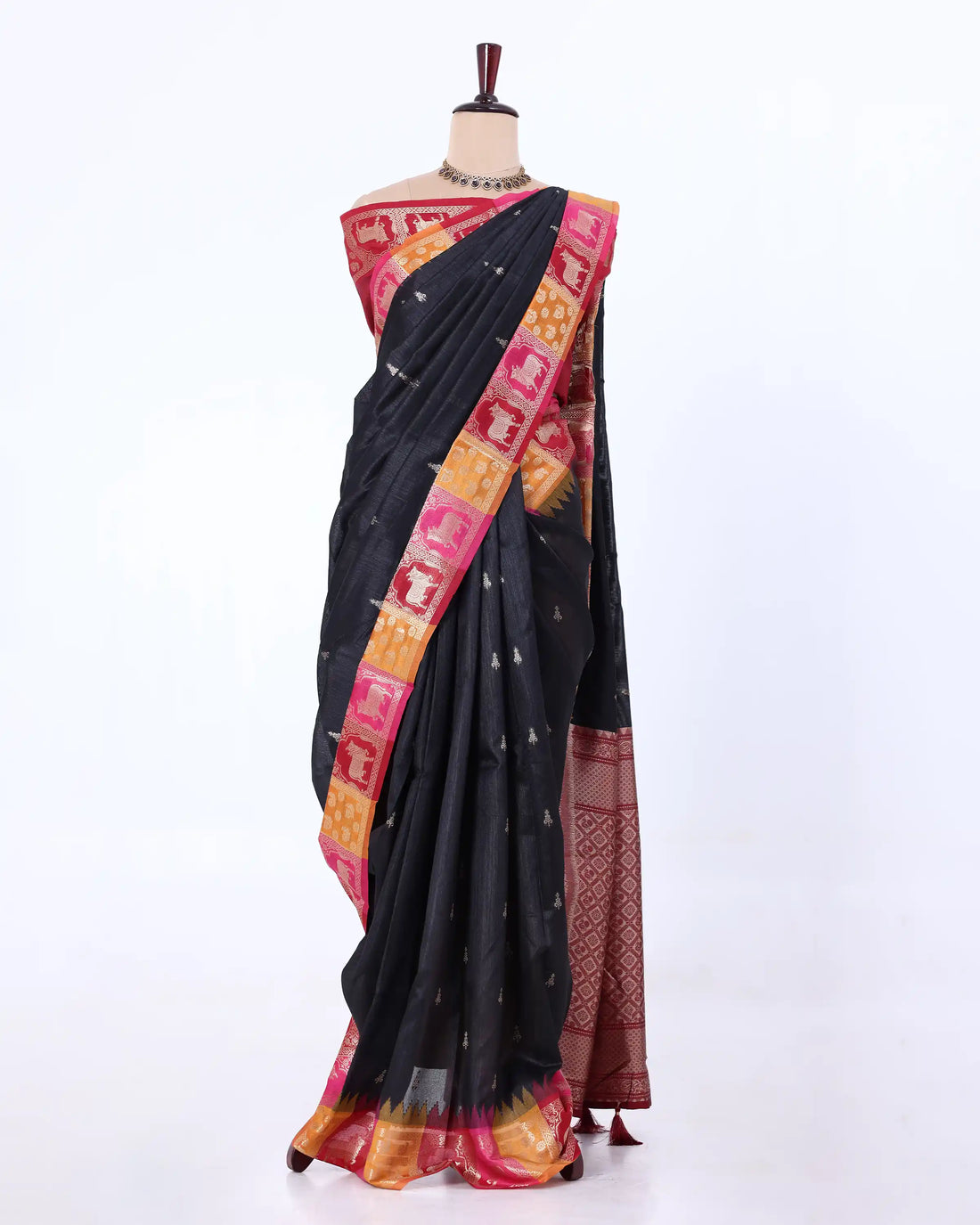 A black cotton saree with a vibrant pink and gold border
