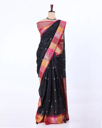 A black raw silk saree with a vibrant pink, orange, and gold border