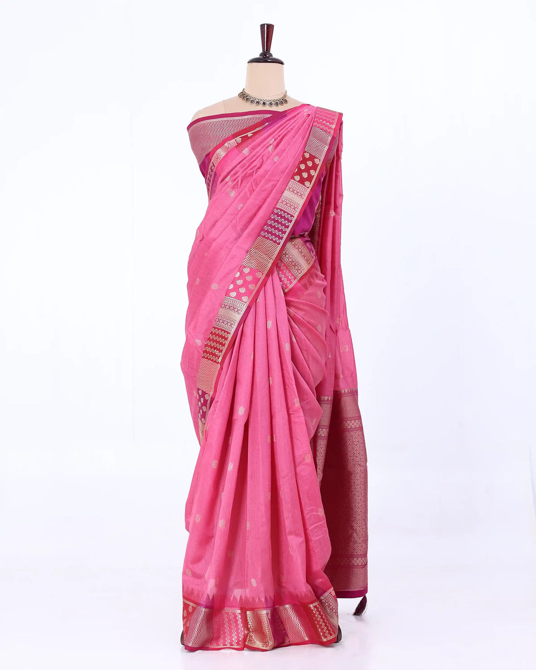 A beige raw silk saree with a pink and orange patterned border