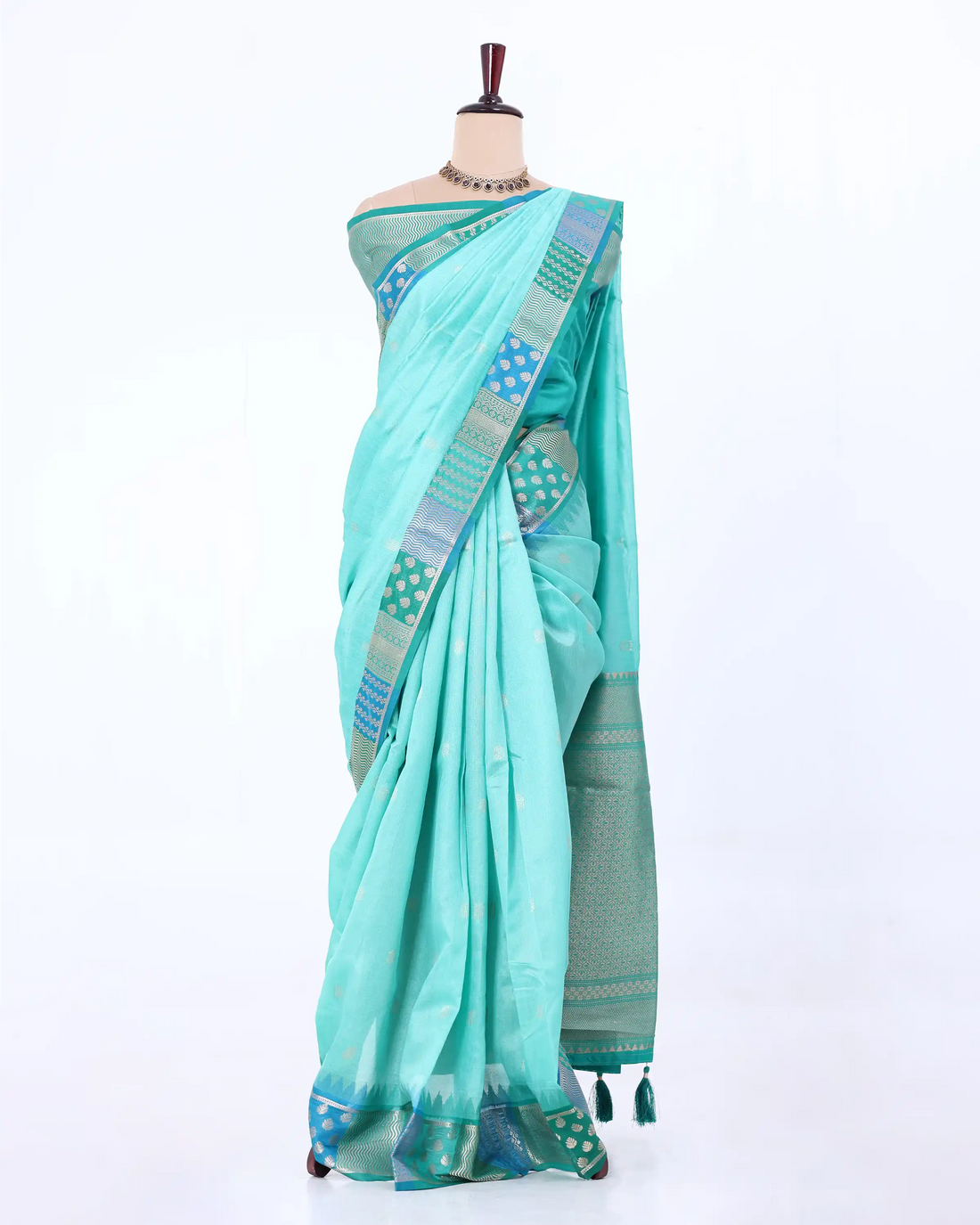 A light turquoise blue saree with a patterned border in shades of blue, green, and beige