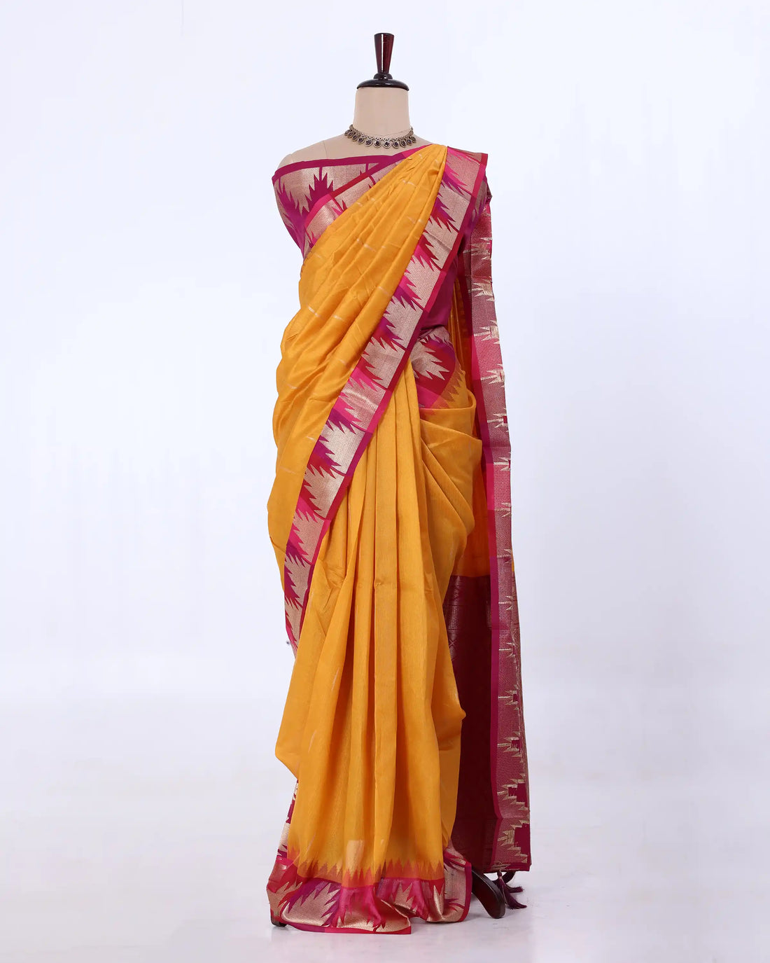 A yellow and magenta saree features a yellow body with a magenta border and a matching magenta pallu.