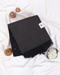 A folded black scarf with a subtle woven texture and fringed edges