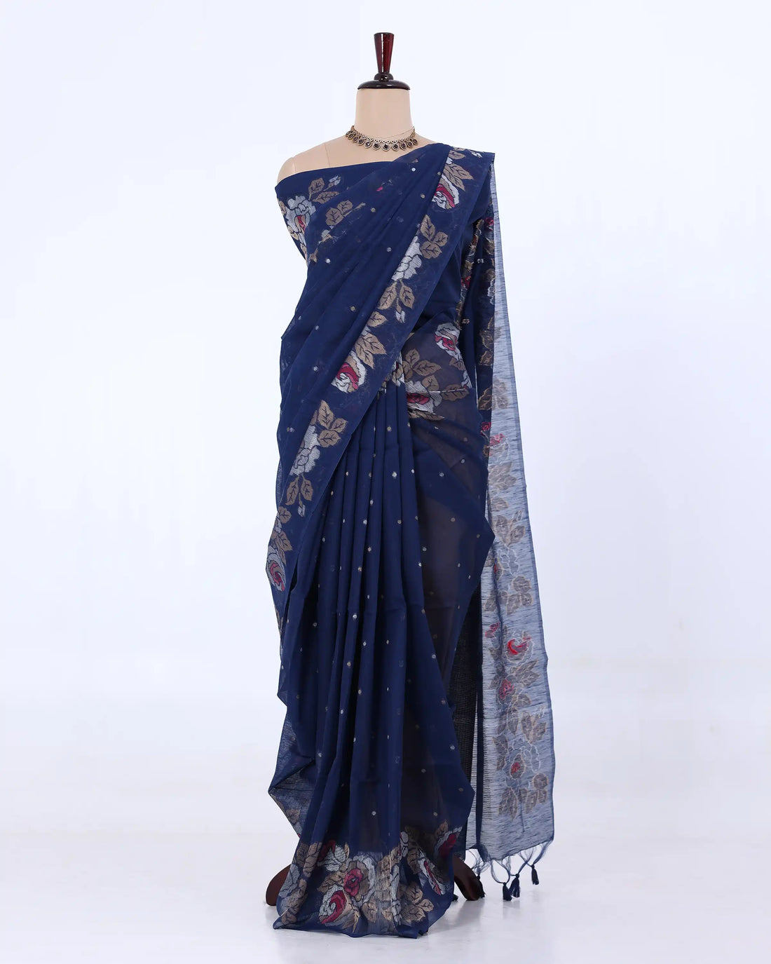 A red saree with gold floral and dot patterns draped on a mannequin against a plain white background.