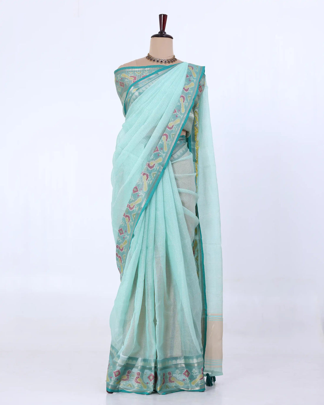 A light mint green saree with a floral patterned border and a beige pallu