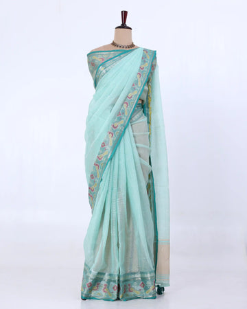 A light mint green saree with a floral patterned border and a beige pallu