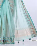 A mint green saree with a wide cream-colored pallu and detailed floral borders