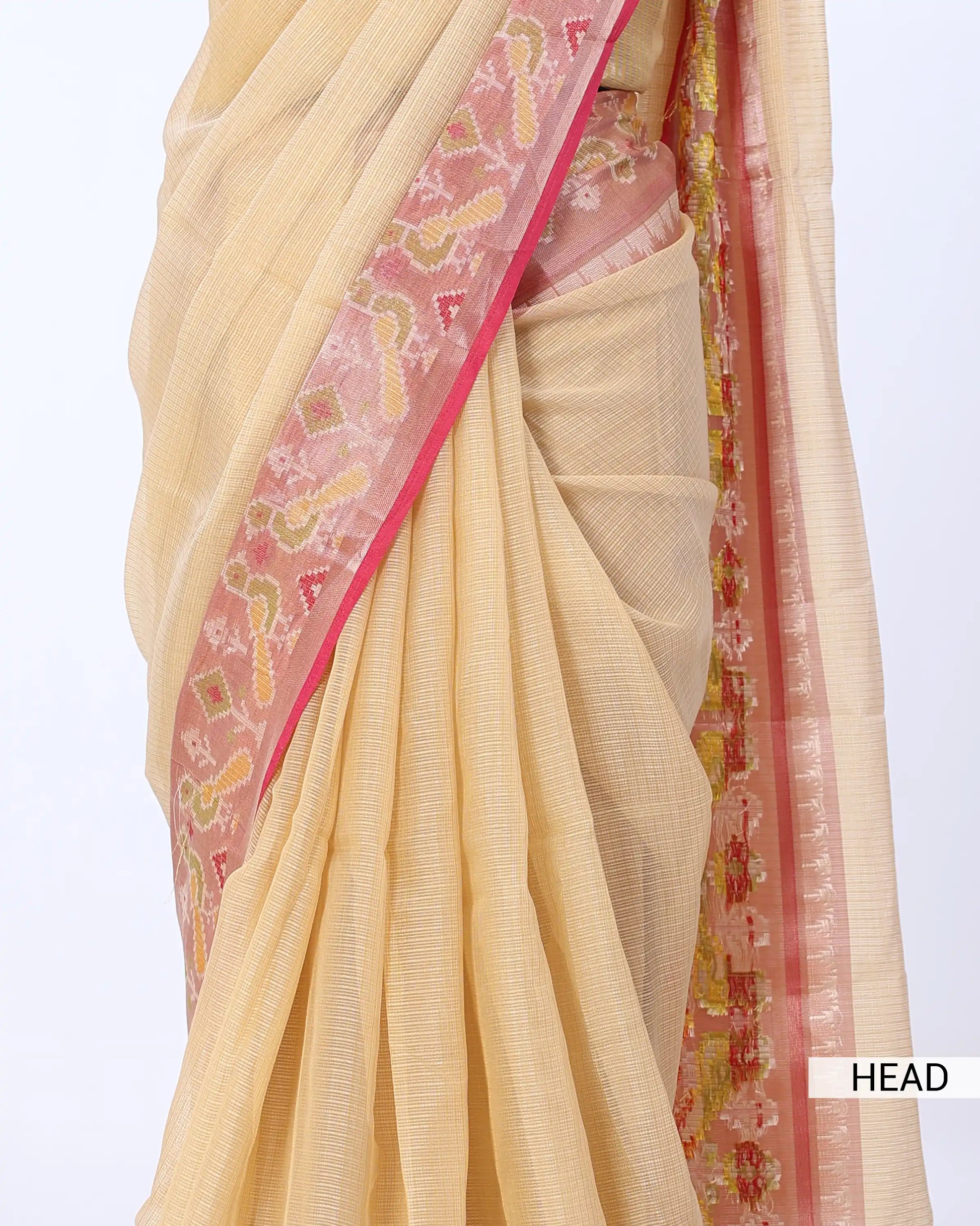 A close-up of a draped cream-colored saree with a pink border and intricate multicolor floral patterns