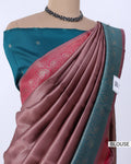 A draped sari featuring a dusty rose pink body with a teal border and a matching teal blouse. The blouse has small metallic embellishments, and the sari has a woven paisley pattern on the border.