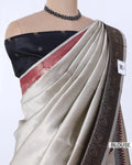 A beige and black checkered saree featuring a dark navy blue blouse with a red border and a wide black paisley border