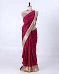 A deep magenta pink silk saree with a beige border and a matching beige blouse
